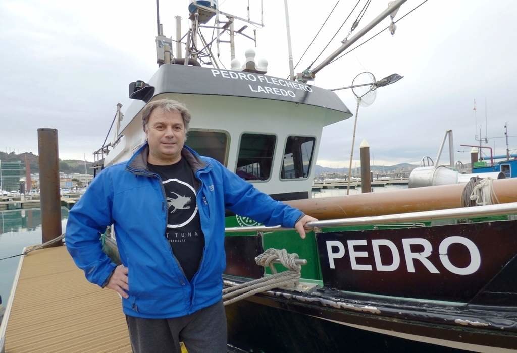 Pedro Pardo (Flechero), junto a su barco en el puerto de Laredo. R.A.
