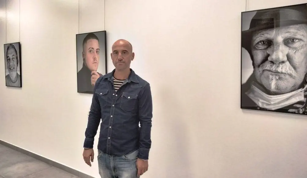 Pedro Bada  junto a varios de sus retratos en la sala de exposiciones de Laredo. Nyka Goicoechea