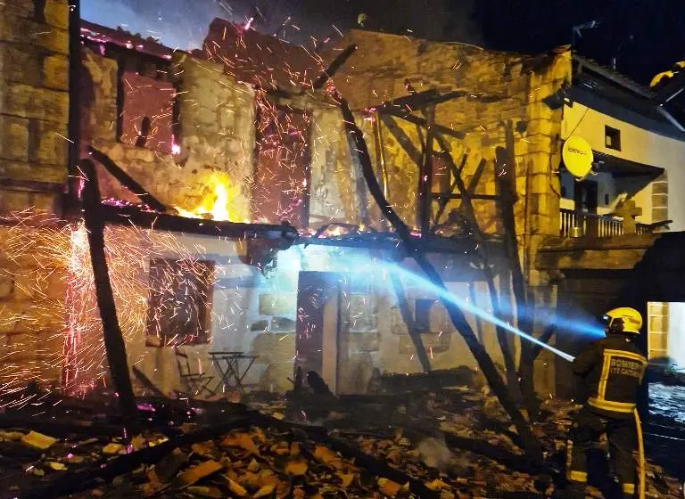 Los Bomberos apagan el incendio en la vivienda.