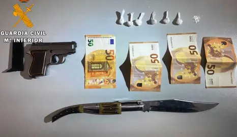 Dinero y armas incautadas por los agentes.