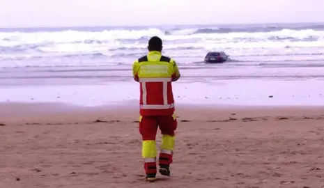 Coche encallado en el mar.