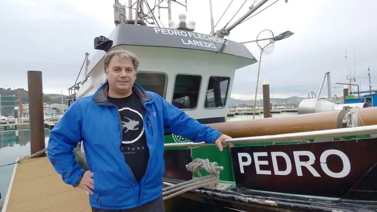 Pedro Pardo (Flechero), junto a su barco en el puerto de Laredo. R.A.