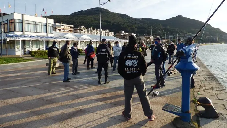 Agentes de la Policía Local de Santoña con los pescadores deportivos. R.A.