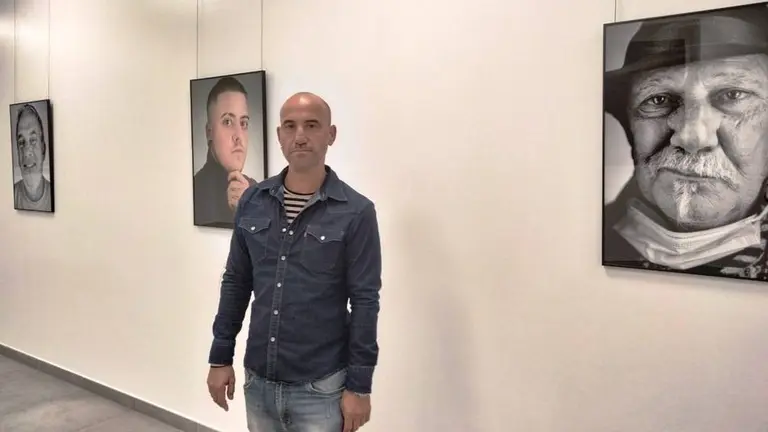 Pedro Bada  junto a varios de sus retratos en la sala de exposiciones de Laredo. Nyka Goicoechea