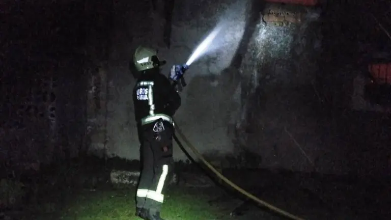 Los Bomberos sofocan el incendio en la vivienda.