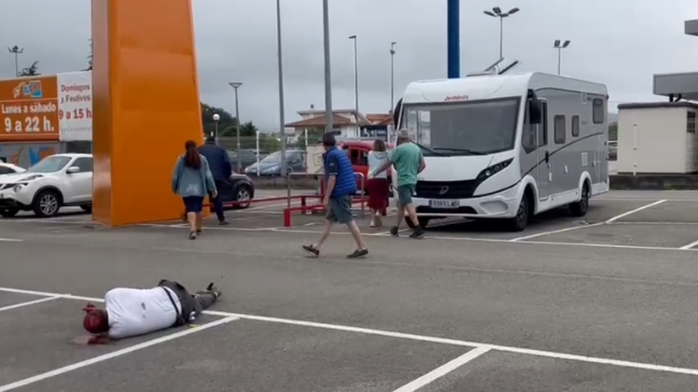 La v&iacute;ctima en el suelo del aparcamiento.