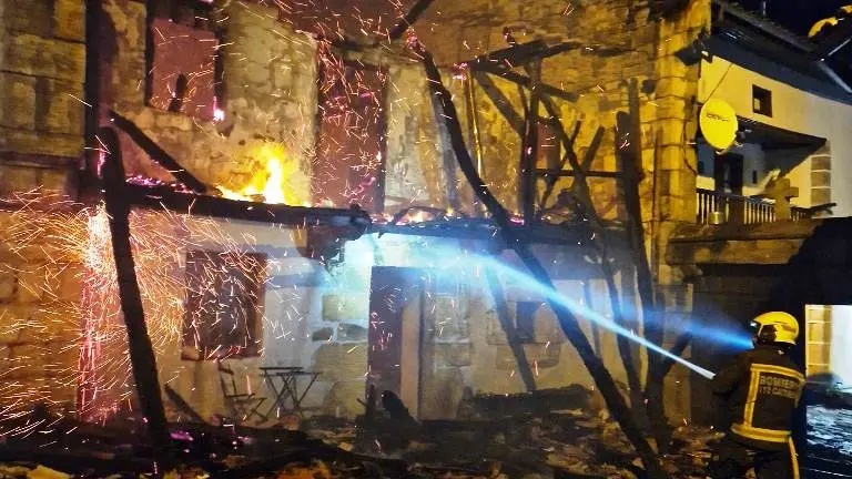 Los Bomberos apagan el incendio en la vivienda.