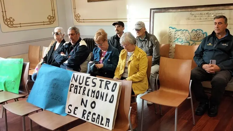 Vecinos que acudieron al Pleno con las pancartas. R.A.