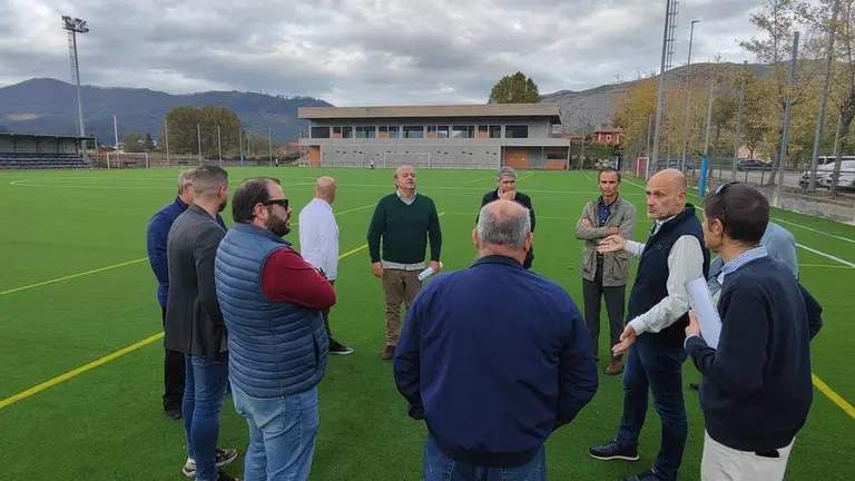 Las autoridades políticas y deportivas en el campo de fútbol de Los Corrales de Buelna.